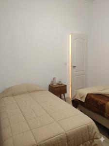 a bedroom with a bed and a door with a table at Depto Muy Patagónico, lindo y cómodo in Trelew +29 photos