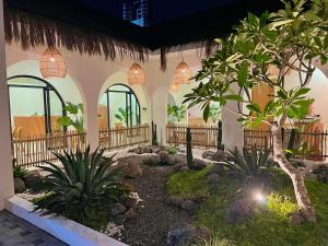 a courtyard of a building with a tree and plants at Numar Villas Yogyakarta in Seturan