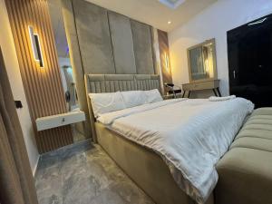a bedroom with a large bed and a chair at Dejuks Hotel & Resort Executive Room in Mama