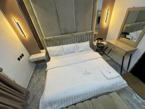 a large white bed in a room with a desk at Dejuks Hotel & Resort Executive Room in Mama
