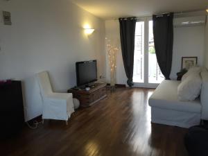 - un salon avec un canapé blanc et une télévision dans l'établissement La casa di Teseo, à Cannizzaro