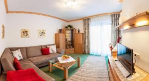 a living room with a couch and a tv at Sportalm Apartments in Leutasch