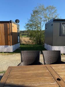 a wooden table with two chairs and a fence at Tinyhaus Altmühlauszeit in Beilngries +5 photos