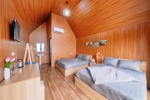 a bedroom with two beds and a television in it at Cat Ba Spring Homestay in Cat Ba +78 photos
