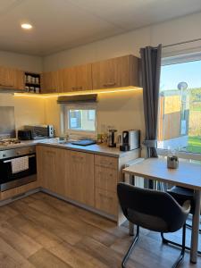 a kitchen with wooden cabinets and a table with a chair at Tinyhaus Altmühlauszeit in Beilngries