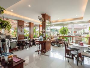 a restaurant with tables and chairs and windows at เดย์ อินน์ บาย วินด์แฮม ระยอง อู่ตะเภา in Ban Chang