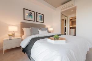 a bedroom with a large white bed with a night stand at King Street Residences in Brisbane +32 photos