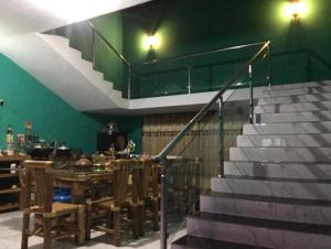 a dining room with a table and a staircase at Lucky villa in Sylhet