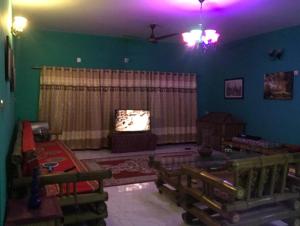 a living room with a couch and a tv at Lucky villa in Sylhet