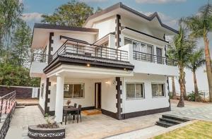 a white house with a patio in front of it at Esperanza Villas by SVAR Stays in Panchgani