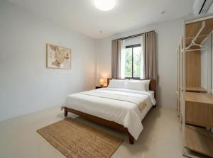 a white bedroom with a large bed and a window at Casa Phangan - Boutique Island Villa in Wok Tum +7 photos