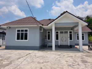a white house with a red roof at Dsurau Homestay in Kota Bharu