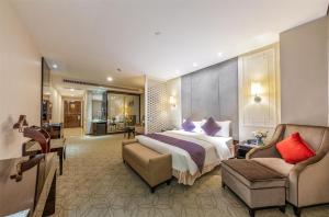 a hotel room with a bed and a chair at Dorsett Wuhan in Wuhan +72 photos
