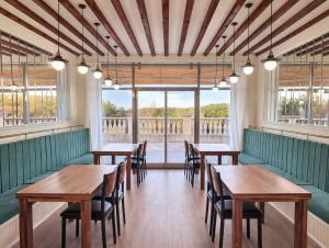 a row of tables and chairs in a room with windows at Kylin Villa resort Jeju in Seogwipo