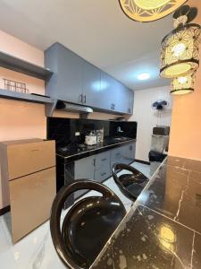 a kitchen with two black chairs at a counter at serene genar in General Trias