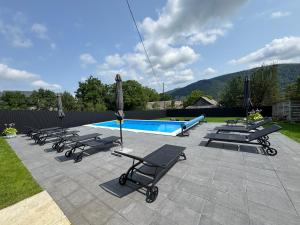 a row of lounge chairs and a swimming pool at Garage in Yaremche