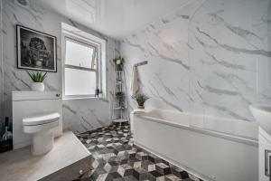 a white bathroom with a tub and a toilet at Clarence House in Llandudno +38 photos