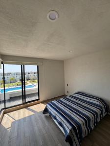 a bedroom with a bed and a large window at Xochitepec Residencial in Atlacholoaya