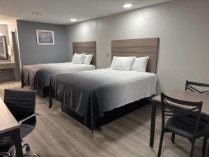 a hotel room with two beds and a table and chairs at Americas Best Value Inn Cabot in Cabot