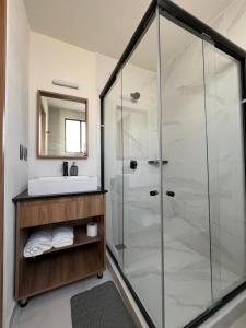 a bathroom with a glass shower and a sink at Xochitepec Residencial in Atlacholoaya +31 photos