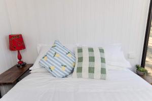 a white bed with two pillows on top of it at Kenny and Clancy's Camp by Tiny Away in Grandchester
