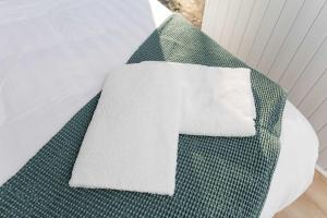 a white towel sitting on top of a bed at Kenny and Clancy's Camp by Tiny Away in Grandchester
