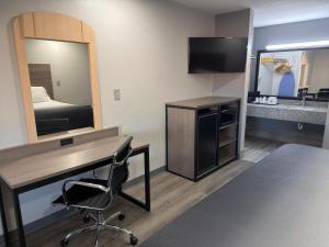 a hotel room with a desk and a mirror at Americas Best Value Inn Cabot in Cabot