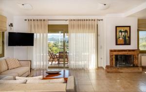 a living room with a couch and a fireplace at Panorama Villa Sitia in Sitia