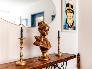 a statue of a woman sitting on a table with two candles at Central Art Apartment with Treasure Hunt, Free Parking & Self Check-In in Constanţa