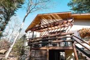 a house with a wooden staircase leading up to it at rinne 北軽井沢 Forest2 in Tsumagoi