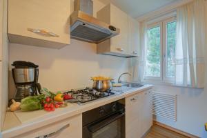 a kitchen with a stove and some vegetables on the counter at Torbole Lake Front - Happy Rentals in Arco