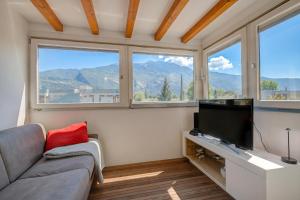 a living room with a couch and a flat screen tv at Torbole Lake Front - Happy Rentals in Arco