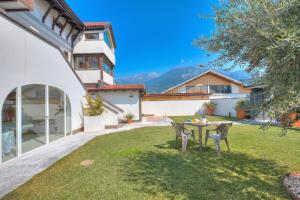 a patio with a table and chairs in a yard at Torbole Lake Front - Happy Rentals in Arco +18 photos