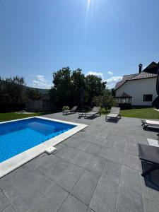 a patio with a swimming pool and some chairs at Garage in Yaremche