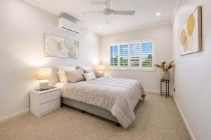 a white bedroom with a bed and a window at Magic on MacArthur - Modern 4BR Home in Annandale in Rosslea +13 photos