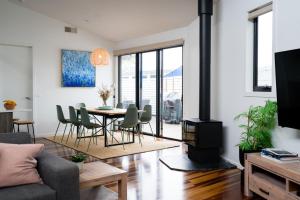 a living room with a table and chairs and a fireplace at The Retreat Inverloch in Inverloch