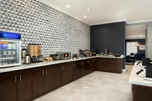 a kitchen with wooden cabinets and a brick wall at Hyatt Select St Louis Airport in Saint Louis