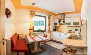 eine kleine Küche mit einem Tisch und einem Waschbecken in der Unterkunft Sportalm Apartments in Leutasch