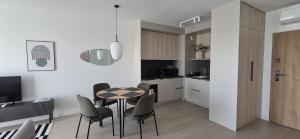 a kitchen and dining room with a table and chairs at Pino 34 Sobieszewo in Gdańsk