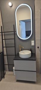 a bathroom with a sink and a mirror at Pino 34 Sobieszewo in Gdańsk