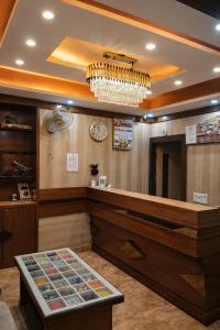 a waiting area with a clock and a chandelier at Hotel Benaras Gharana Inn in Varanasi