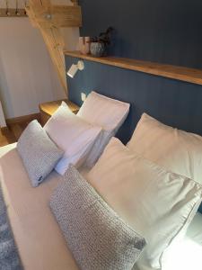 a bed with white pillows and a blue wall at La Villa de Paul - Les Chambres in Yenne