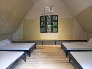 a room with three beds and a window at Campo De Laiya in San Juan