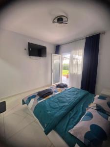 a bedroom with a large bed and a window at Casa Matei Gabriel in 2 Mai