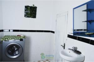 a bathroom with a washing machine and a sink at earth home in Imzoûrene +7 photos