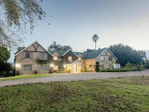 a large house with lights on a driveway at Portland Manor in Knysna