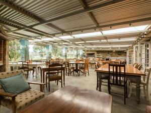 a restaurant with wooden tables and chairs and tablesearcher at Portland Manor in Knysna