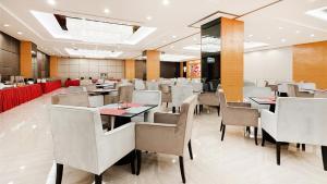 a restaurant with tables and chairs in a room at Dorsett Wuhan in Wuhan