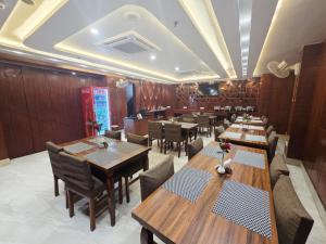 a dining room with wooden tables and chairs at Hotel Mantavya in Kakarmatha