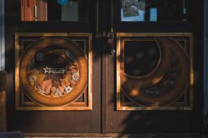 two wooden doors with a wreath on them at Hakuba Pension & Log Hotel Meteor in Hakuba